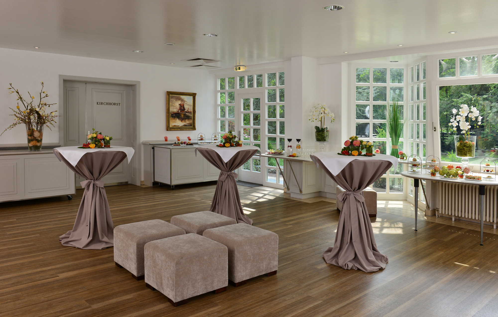Festlich dekoriertes Tagungsfoyer mit Frühlingsdekoration und großen Fenstern mit Blick ins Grüne.