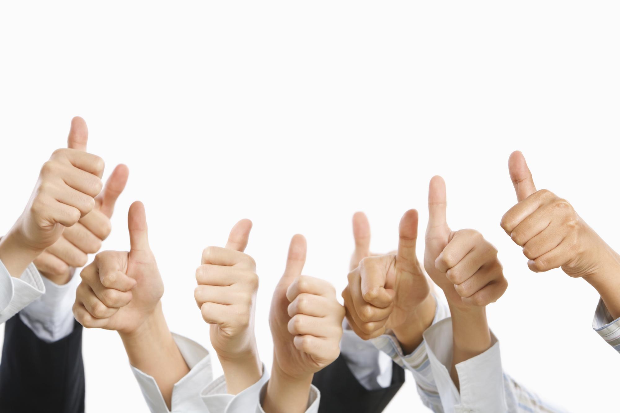 Viele Hände in Businesskleidung zeigen Daumen nach oben auf weißem Hintergrund.